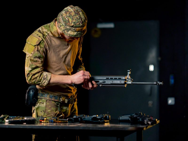 in a professional shooting range a professional fighter assembles a NATO assault rifle